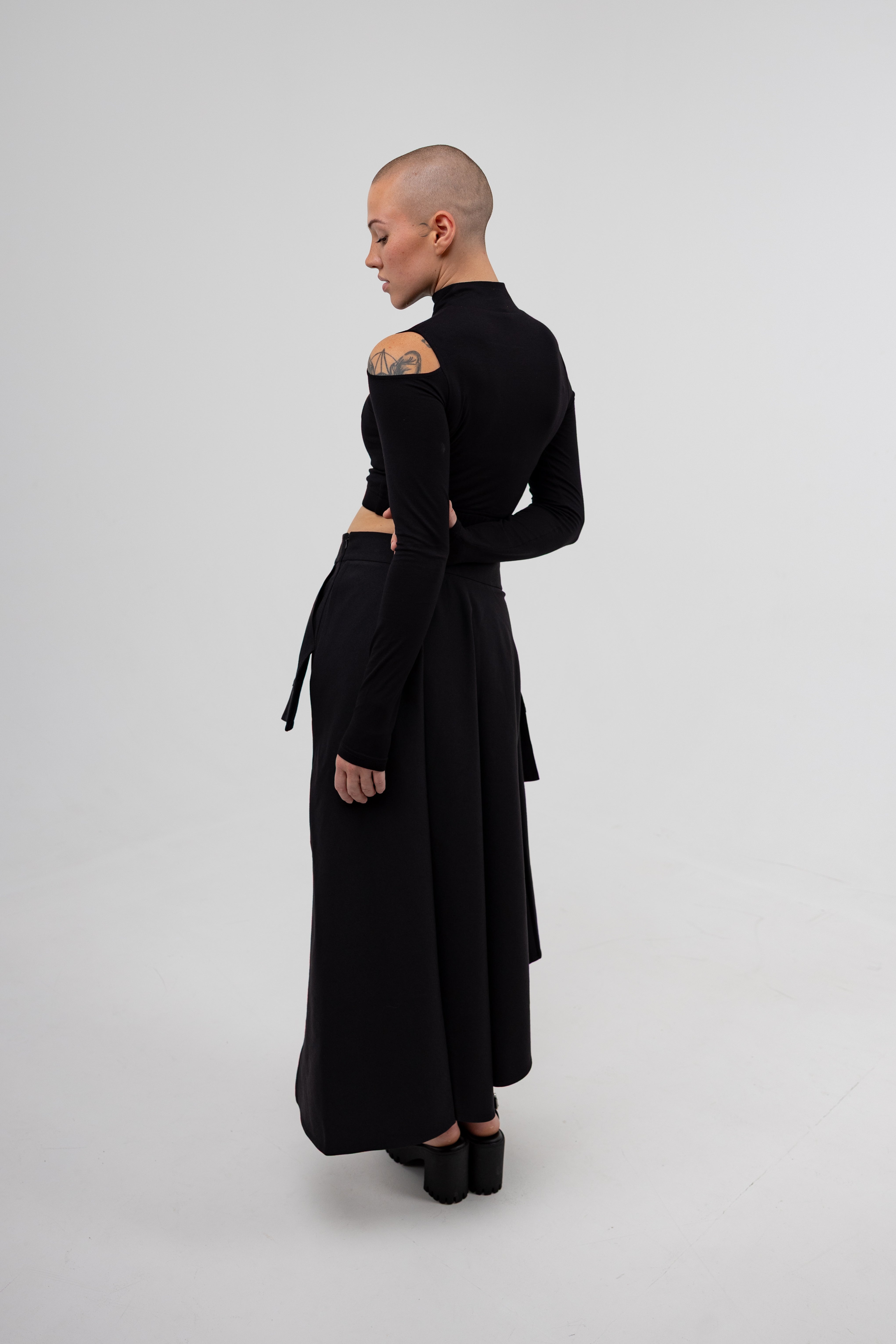 Person wearing a black dress with cut-out design on a white background