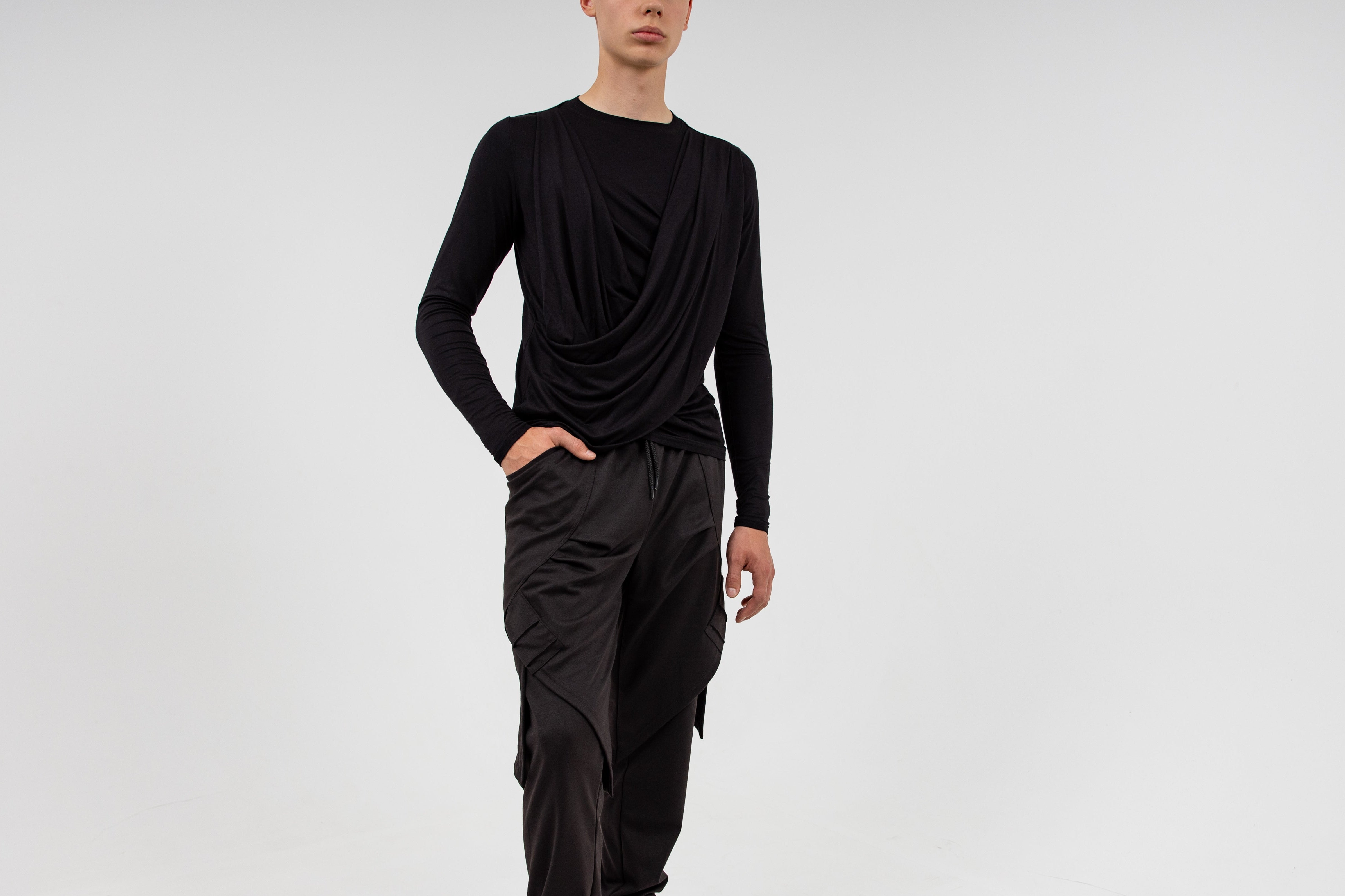 contemporary drapewear brand clothing by a black long-sleeve top and black cargo pants on a white background