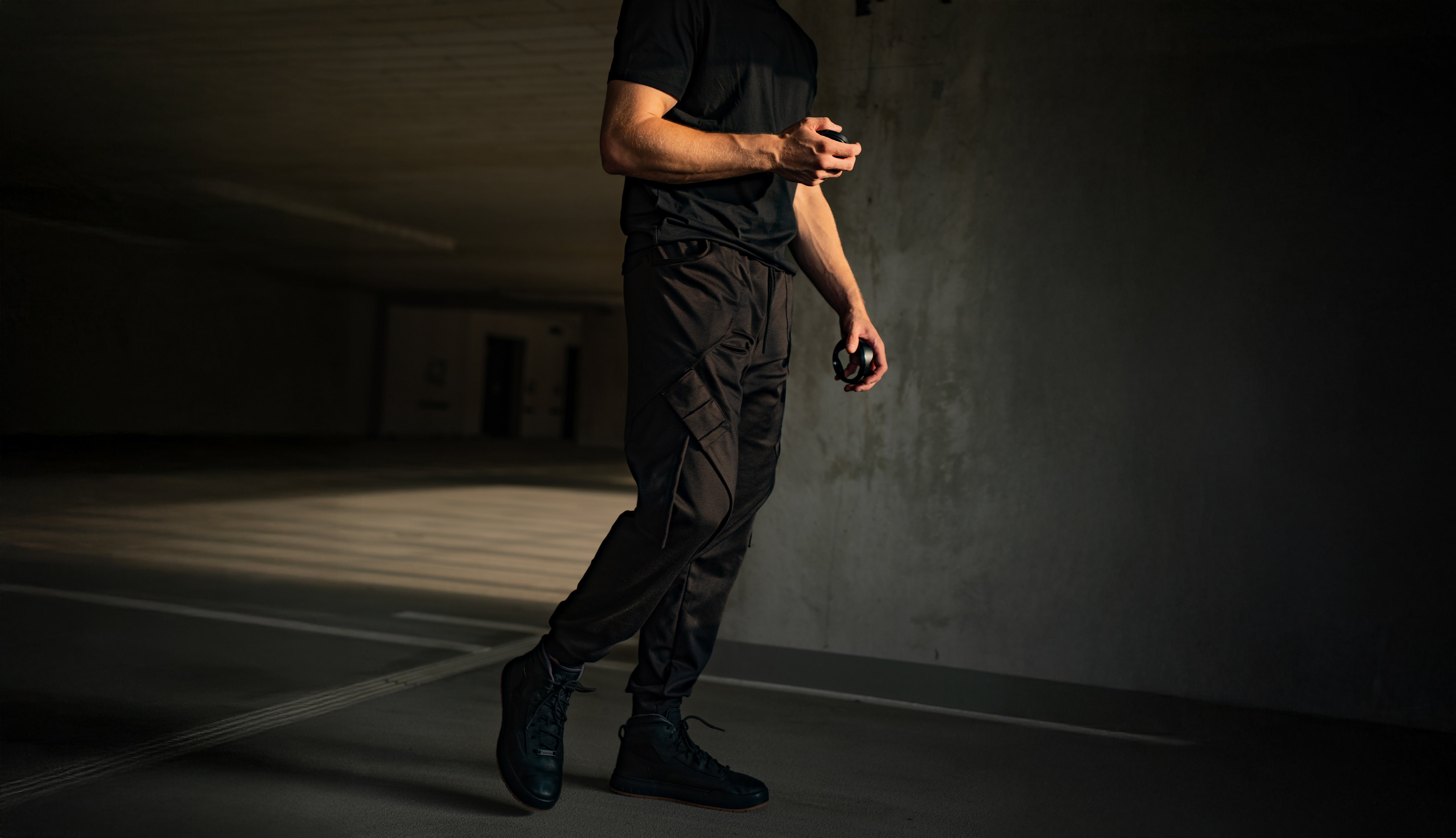 Person wearing dark clothing in a dimly lit room