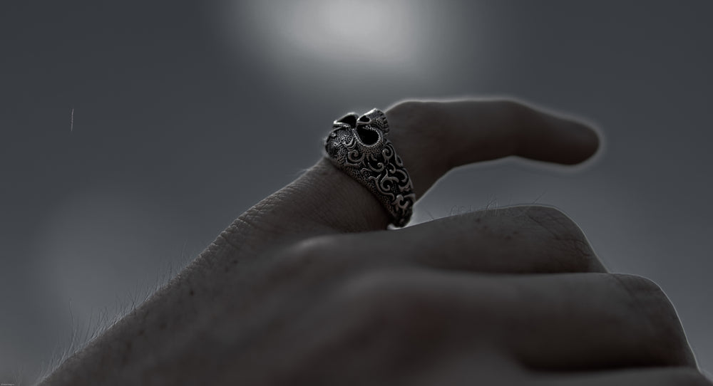 male pointing to the sky of cosmos wearing luxury skull ring from stainless steel and inspired by techwear, gothic, punk, biker and streetwear style