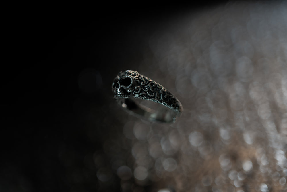 skull ring made from sterling silver hanging in the air next to veil of cosmos and releasing soul energy to deliver designer fashion jewelry from gothic, techwear and streetwear style for men and women