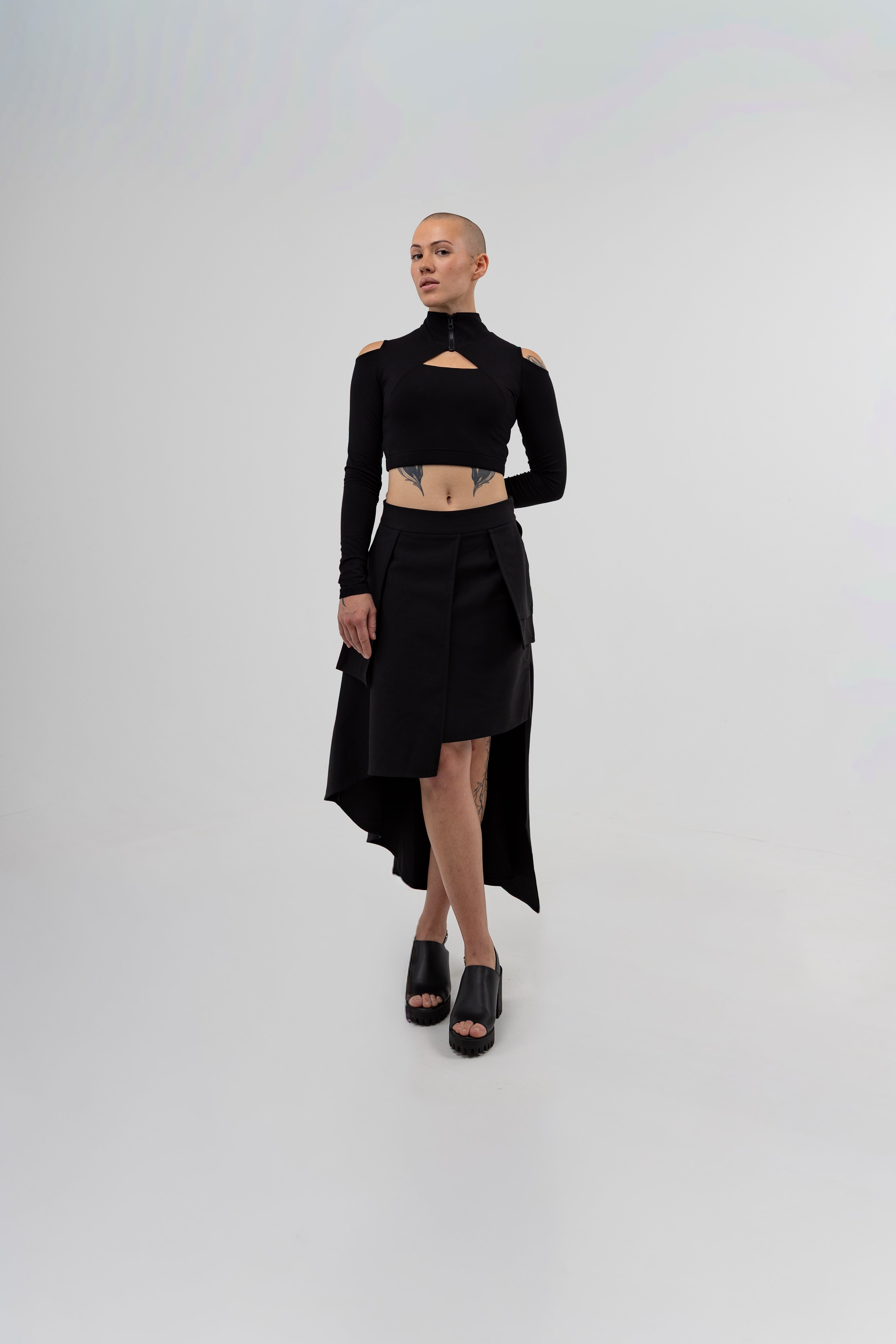 Person wearing a black outfit with cut-out details on a white background