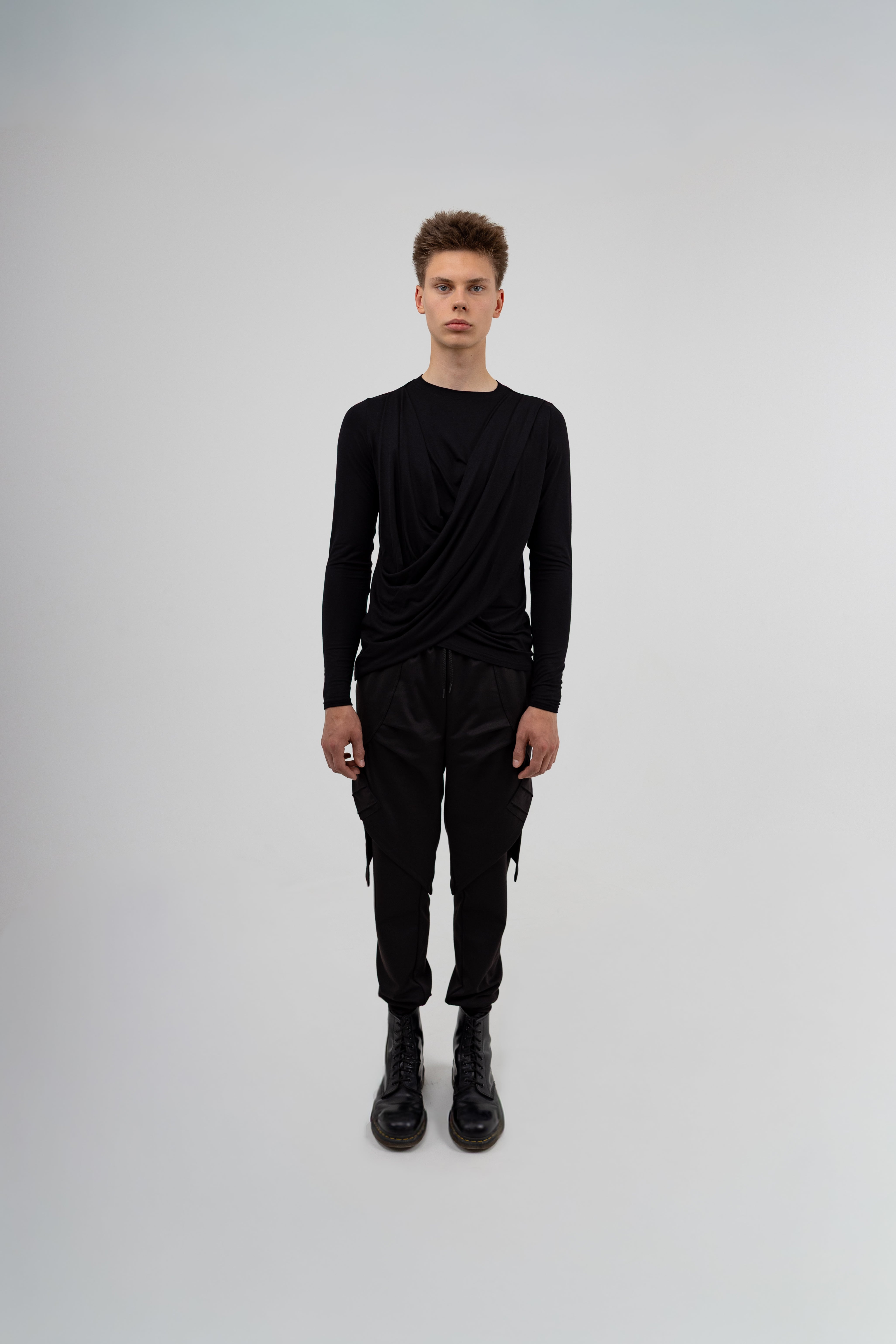 Person wearing a black outfit on a gray background